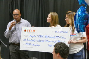 Lee Lambert of Washington STEM gives a $111,000 check to Sue Kane and Jenny Rojanasthien of the Apple STEM Network Saturday